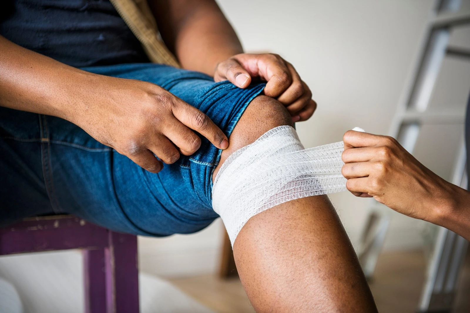 A person's knee being bandaged after an injury