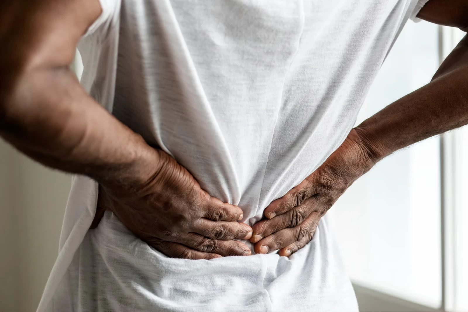 A person holding their lower back in pain